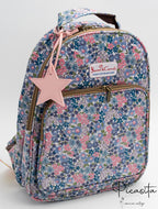 Mochila con estampado floral en tonos azules y rosas con estrella decorativa rosa.