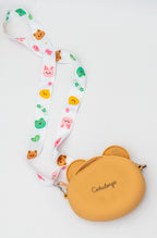 Parte trasera de bolso de silicona marrón con nombre personalizado y correa de personajes.