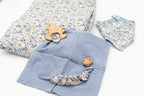 Ensemble bleu avec couverture fleurie, bavoir bandana, lange bleu avec anneau de dentition cheval à bascule en bois et attache-tétine à pince en bois.