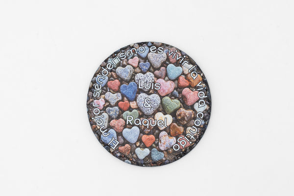 Dessous de verre rond en ardoise avec cœurs colorés et prénoms personnalisés.