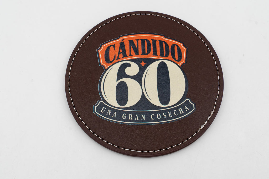 Sous-verre rond marron avec motif d'anniversaire Cándido 60 en couleur.