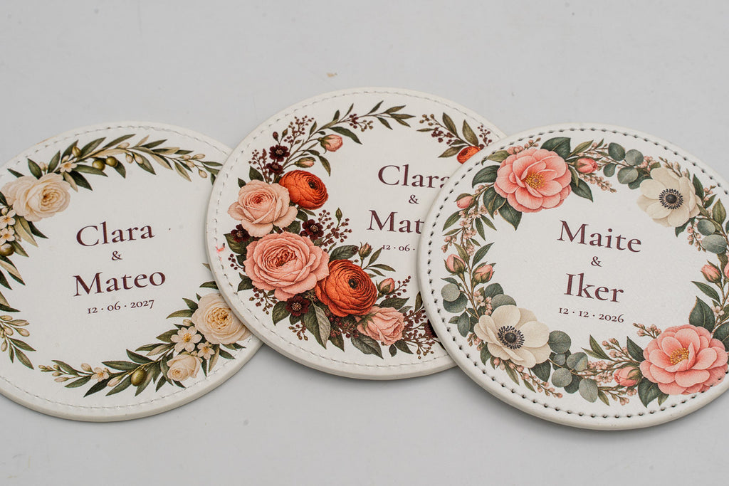 Trois sous-verres ronds blancs avec fleurs en couleur et prénoms de mariés.