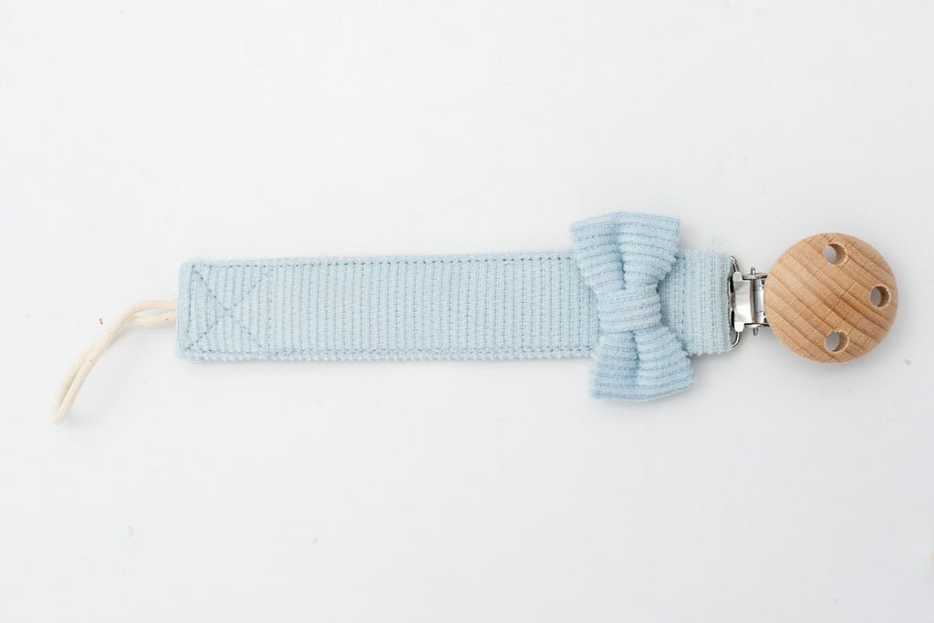 Attache-tétine bleu clair avec nœud près du clip rond en bois