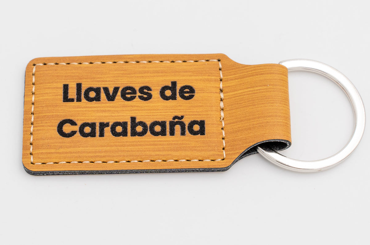 Porte-clé rectangulaire aspect bois avec texte foncé sur deux lignes.