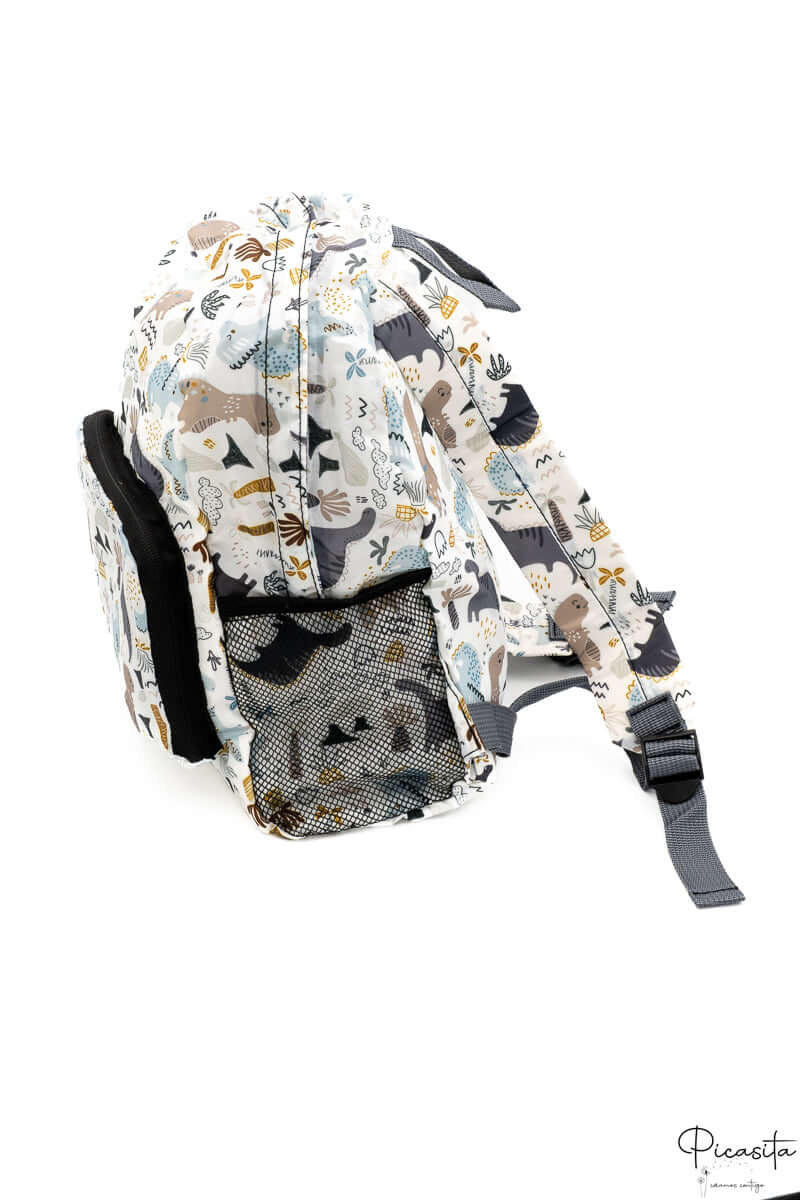 Perspectiva lateral de la mochila infantil plegable con detalle del ajuste de las correas.