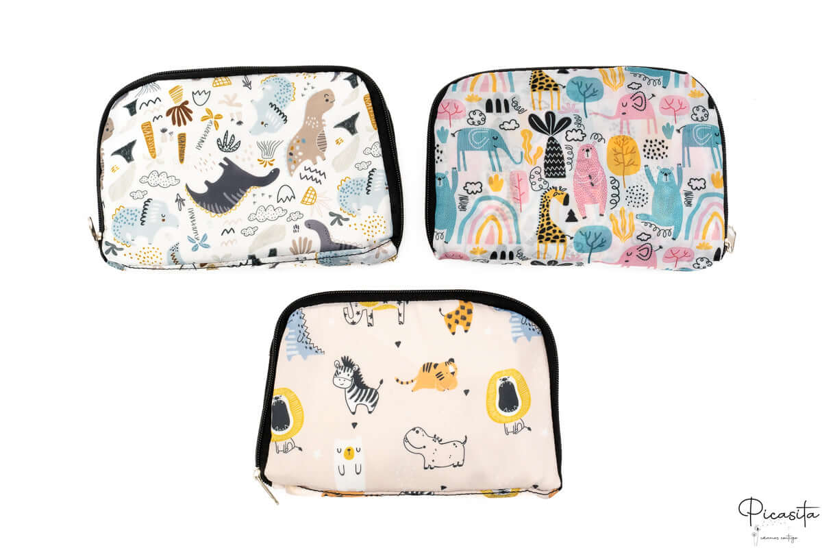 Tres neceseres plegados que muestran los tres estampados disponibles de la colección infantil.