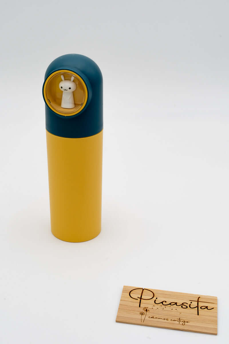 Estuche azul y amarillo junto a placa de madera con logotipo de Picasita.