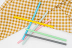 Pailles droites en silicone coloré sur un tissu à carreaux