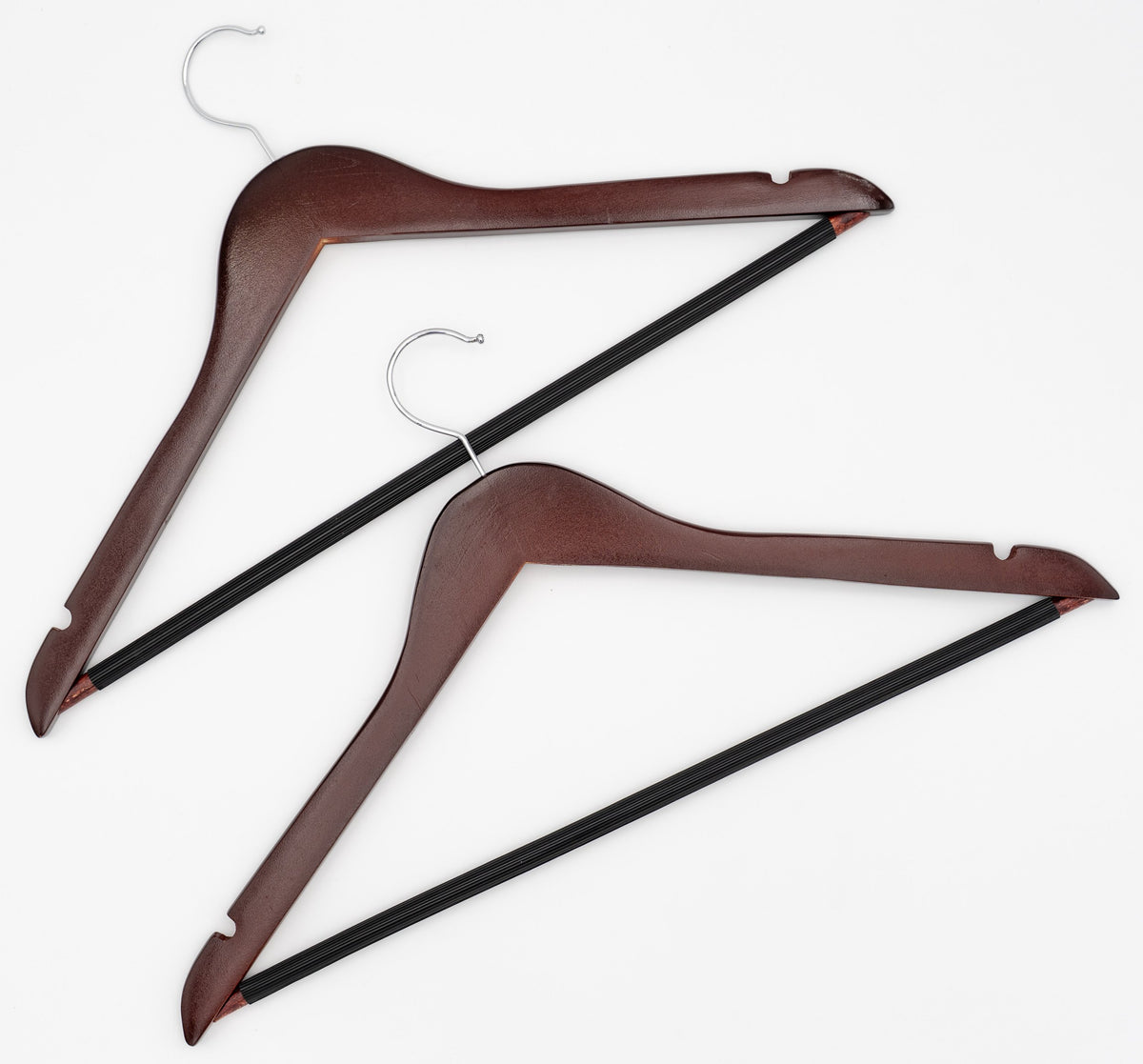 Deux cintres en bois foncé avec crochet métallique et barre noire pour pantalons.