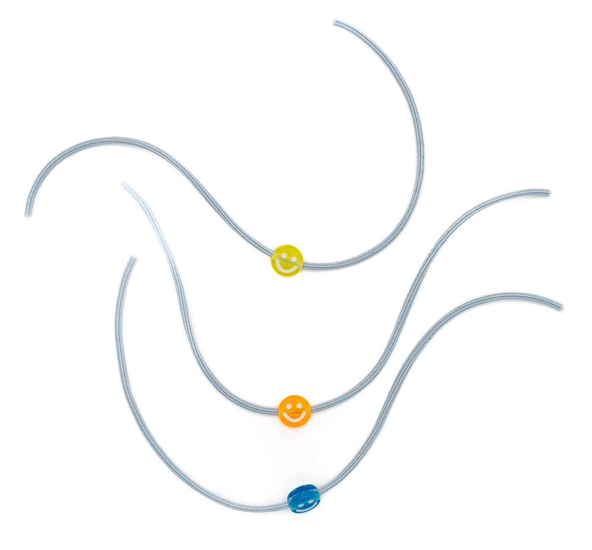 Trois bracelets élastiques gris avec perles en forme de sourire jaunes, orange et bleues