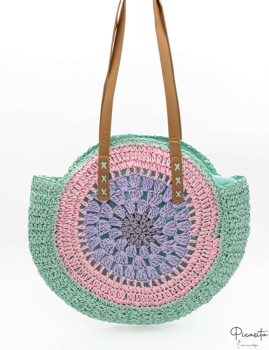 Bolso circular trenzado con diseño de círculos concéntricos en tonos pastel.