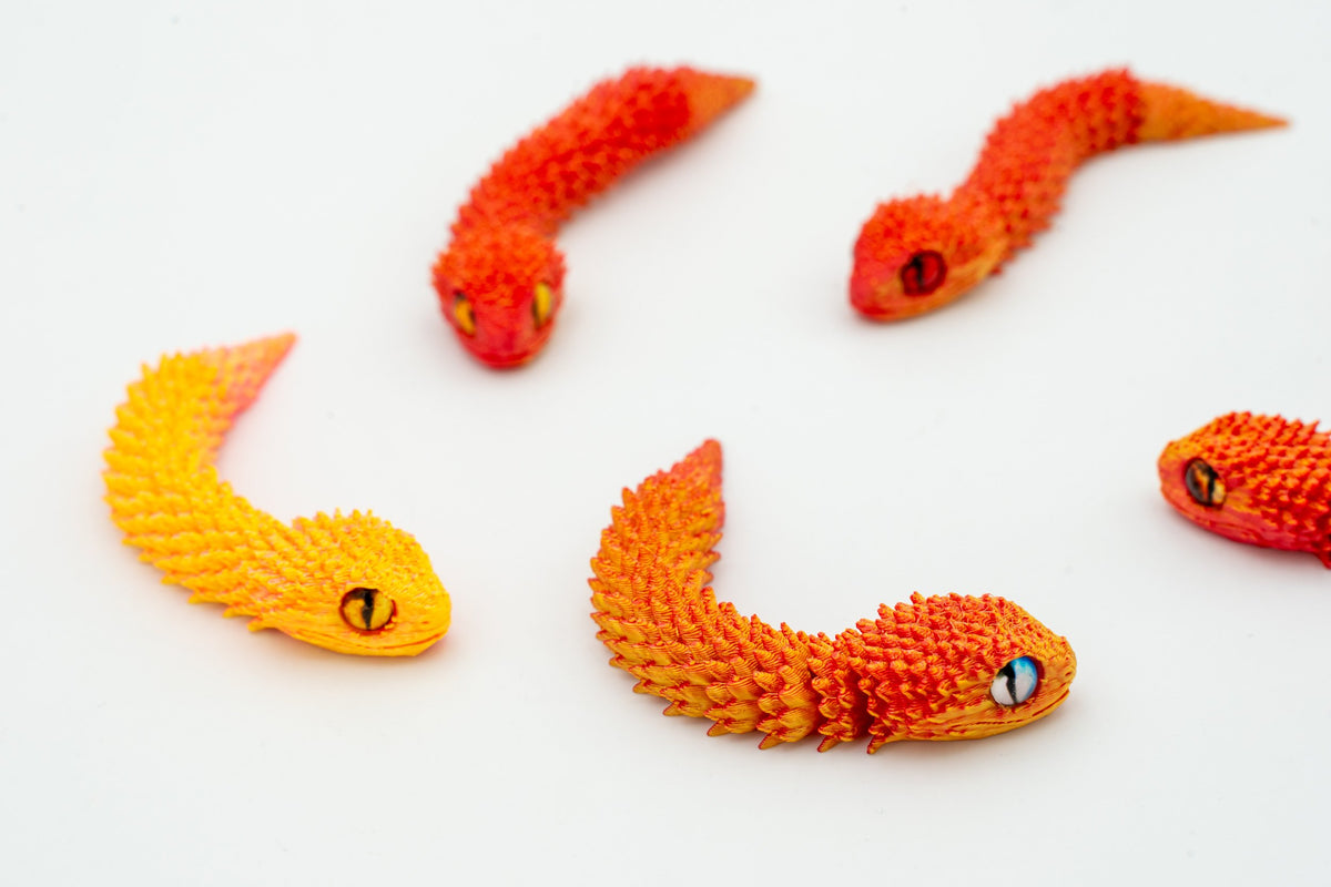 Serpents 3D articulés en dégradé orange et jaune vus de près