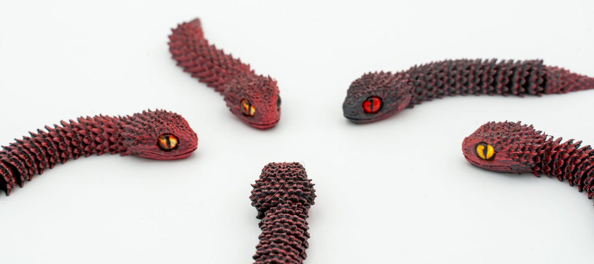 Serpents 3D articulés dans des tons rouge foncé en détail